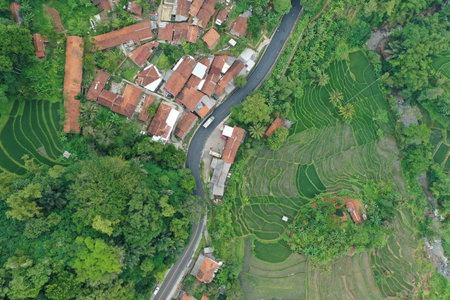 Sprawling green rice fields and villages east of the city of Bandung, West Java. Indonesia. This is an out-of-town area with vast rice fields, surrounded by tropical hills and mounの写真素材