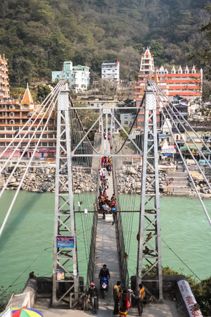 RISHIKESH, INDIA - February, 12th, 2012. Beautiful view of Ganga river embankment, Lakshman Jhula bridge and Tera Manzil Temple, Trimbakeshwar in Rishikeshのeditorial素材