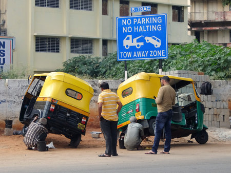 Bangalore, India - November, 19th, 2017. Taxi drivers on the street of Bangalore, repairing...