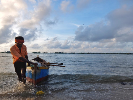 Rameshwaram, India - November, 21st, 2017. Fisherman pulling his boat on the beach after fishing.のeditorial素材