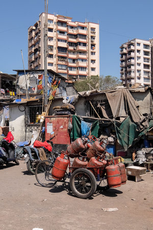 Bicycle with gas tanks in poor district Colaba, Mumbai. New buildings in the background