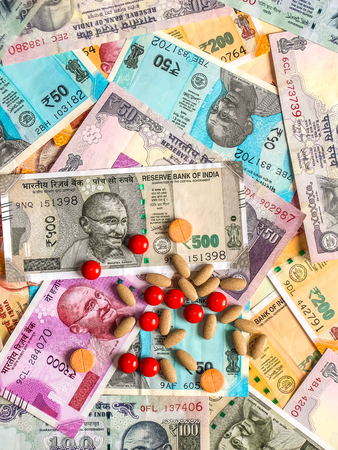 Pills over the 10, 20, 50, 100, 200, 500 and 2000 Indian rupees, old and new notes.の写真素材