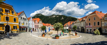 Frohnleiten, Austria - August, 14th, 2017. Panoramic view of the main street of Frohnleiten in bright sunny day. Clouds and mountain in background.のeditorial素材