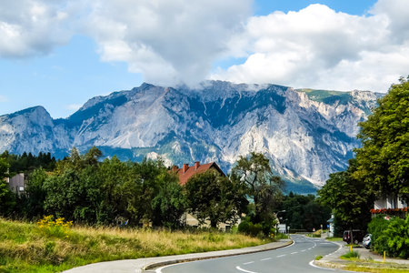 Thorl, Austria - August, 20th, 2017. View of road curves in small town near the Austrian-Italian border with mountains and cloudy sky in background.のeditorial素材