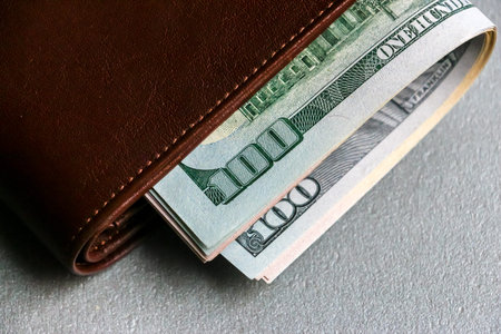 Closeup view of wallet with one hundred and fifty dollar banknotes.