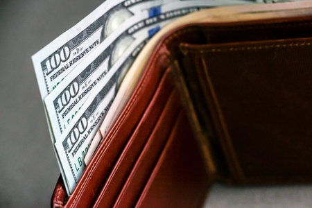 Closeup view of wallet with one hundred and fifty dollar banknotes.の写真素材