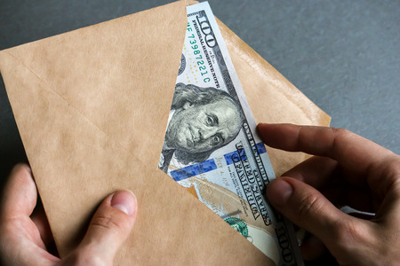 Hands holding envelope with dollar banknotes.の写真素材