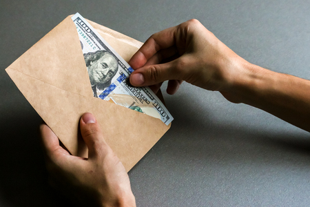 Hands holding envelope with dollar banknotes.の写真素材