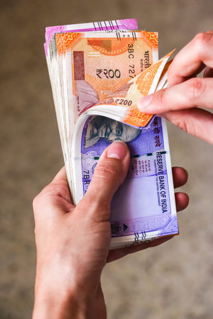 Woman's hands holding brand new indian 100, 200, 500, 2000 rupees banknotes.