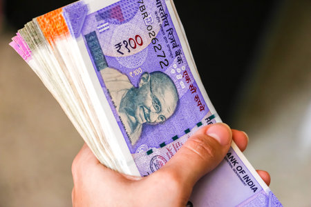 Woman's hands holding brand new indian 100, 200, 500, 2000 rupees banknotes.の写真素材