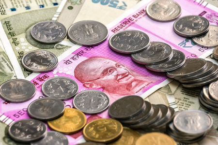 Close up view of brand new indian 2000 rupees banknote and coins. 500 rupee banknotes in background.