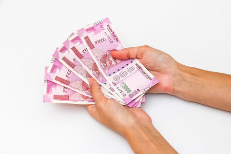 Female hands holding brand new 2000 indian rupees banknotes.