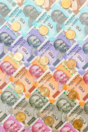 Close up view of brand new indian 10, 50, 100, 200, 500 and 2000 rupees banknotes and five rupee coins. Colorful money ornamental background.の写真素材