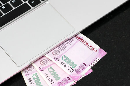 Close up view of brand new indian 2000 rupees banknotes and  laptop.