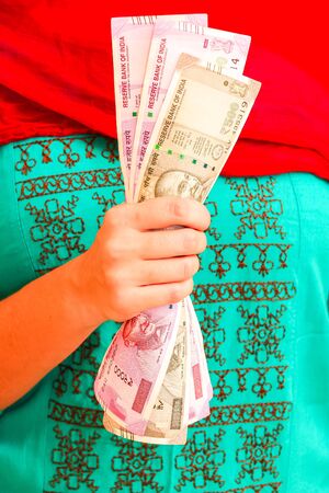 Female hands holding brand new indian 500 and 2000 rupees banknotes.の写真素材