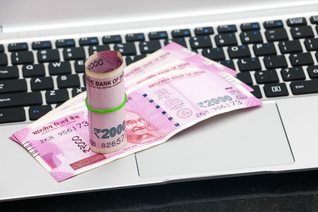Close up view of brand new indian 2000 rupees banknotes and  laptop.