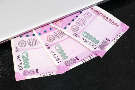 Close up view of brand new indian 2000 rupees banknotes and  laptop.