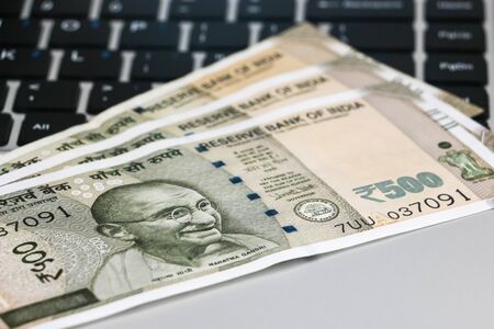 Close up view of brand new indian 500 rupees banknotes and  laptop.の写真素材