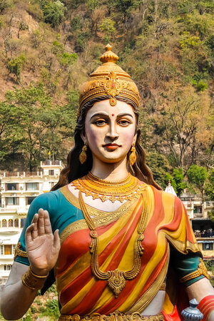 Rishikesh, India - Circa April 2018. Statue of sitting goddess Parvati on the riverbank of Ganga in...