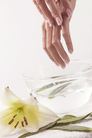 Beautiful female hands with french manicure preparing for getting spa procedureの写真素材