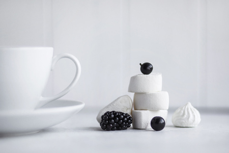 Cup of coffee, white background. Marshmallows, blue, black berries. Blueberries, blackberries, black currants.の写真素材