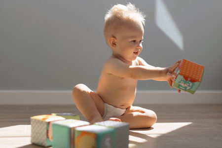 Cute little boy child playing at home with colorful cubes