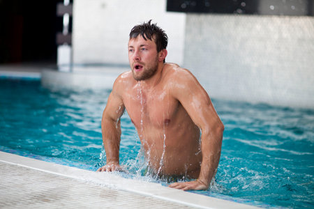 Young handsome Man Swimming In the Pool