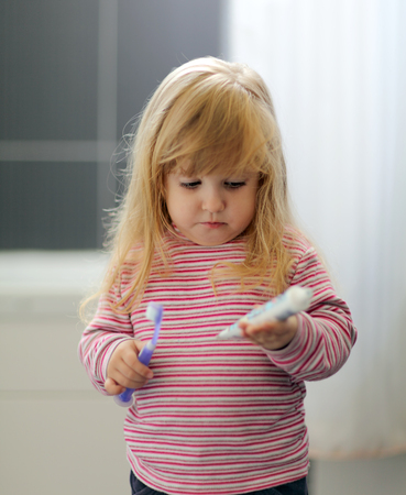 A little girl brushing her teeth at bathroomの写真素材