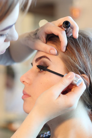 Closeup of a makeup artist applying makeup