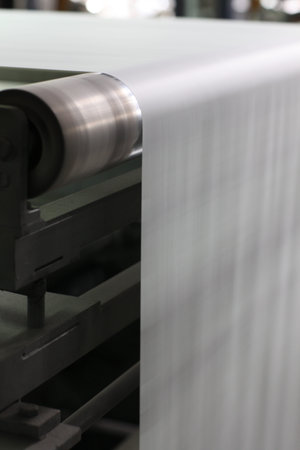 Spools of paper .Working print machine. selective focus on metal shafts and screws