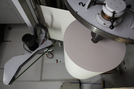 Spools of paper .Working print machine. selective focus on metal shafts and screws