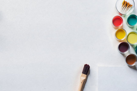 Top view of watercolor paints and paintbrushes on white backgroundの素材
