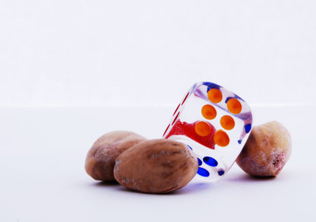 the photo of dice and pistachio on white background