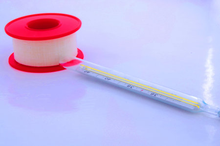 foto of plaster and clinical thermometer on white background