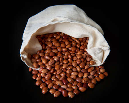 Closeup image of ecological pinto beans in a white canvas bagの写真素材