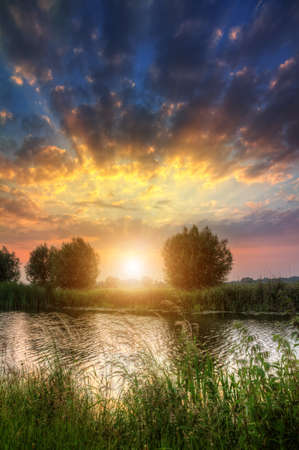 Beautiful vibrant HDR sunset with clouds at the river Angstel in the Netherlandsの写真素材