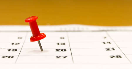 Red push pin selecting a date on the calendarの写真素材
