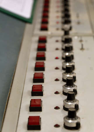 A row of buttons and switches on an old control panelの写真素材