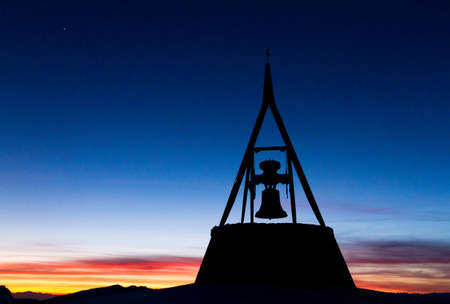 Large bell monument on top of the Kronplatz, italy, at twilightの写真素材