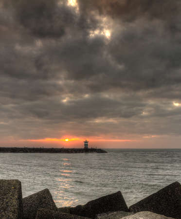 HDR image of the concrete blocks which form the jetty on a cloudy day at sunset in Scheveningen, Netherlandsのeditorial素材