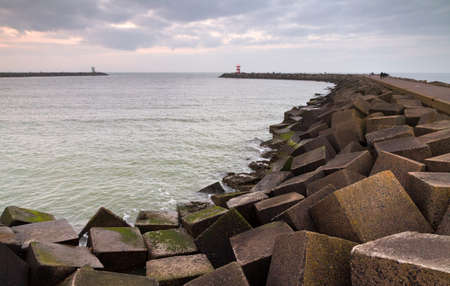 Concrete blocks of the jetty at sunset in Scheveningen, the Netherlandsのeditorial素材