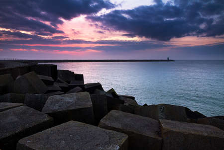 Concrete blocks of the jetty at sunset in Scheveningen, the Netherlandsのeditorial素材