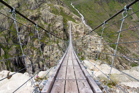 Trift Bridge is the longest pedestrian-only suspension bridge in the Alps, totaling 170 metres  560 ft  in length and traversing a height of 100 metres  330 ft   The bridge spans the lake, Triftsee, near Gadmen, Switzerlandの写真素材