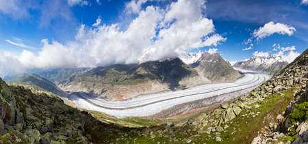Extraordinairy panorama of the breathtaking Aletsch glacier as seen from the Bettmer alp in switserland, on a sunny day with clouds in summerの写真素材