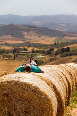 Taking a afternoon sleep on some hay bales in Tuscany, Italyの写真素材