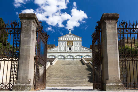 The gates of St  Minias on the Mountain and the basilica on top of the stairs in Florence, Italyの写真素材