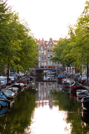 Typical view on a canal in Amsterdam, the Netherlands, with townhouses at the endのeditorial素材