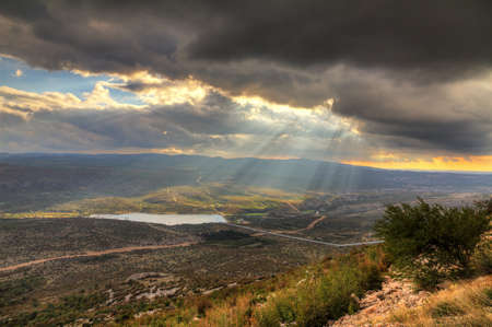 Beautiful view over the landscape near Zadar in Croatia in autumn, with a nice cloudscape and sun beamsの写真素材