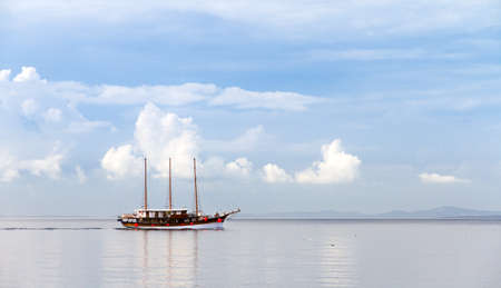 Beautiful ship sailing on a calm sea with a nice cloudscapeの写真素材