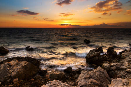 Beautiful sunset in Croatia with rocky shoresの写真素材